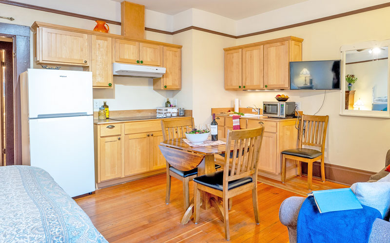 Falls-Suite-Kitchen-Area-at-Victoria-Falls-House-Nelson-BC Compact kitchen area with a dining table in the Falls Suite at Victoria Falls House, Nelson BC.