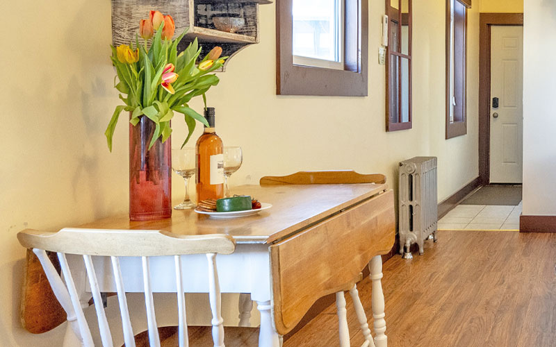 Herridge-Suite-Dining-Area-at-Victoria-Falls-House-Inn-Nelson-BC Intimate dining area in the Herridge Suite at Victoria Falls House Inn, Nelson, BC, featuring a vintage white drop-leaf table.